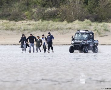 French National Police chase migrants with a buggy vehicle to prevent them from boarding a smuggler's boat in an attempt to cross the English Channel, on the beach of Gravelines, near Dunkirk, northern France on April 26, 2024. - Five migrants, including a seven-year-old girl, died on April 23, 2024 trying to cross the Channel from France to Britain, local authorities said, just hours after Britain passed a controversial bill to deport asylum seekers to Rwanda. (Photo by Sameer Al-DOUMY / AFP)