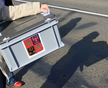 Two members of the Electoral Commission carry a portable ballot box as they go visit voters in the outskirts of Kyjov, southern Czech Republic on October 25, 2013, the first day of the Czech general elections. Czechs began voting in a two-day snap election that will likely see them hand power to the left-wing opposition in frustration over years of graft and austerity. AFP PHOTO / RADEK MICA (Photo by RADEK MICA / AFP)